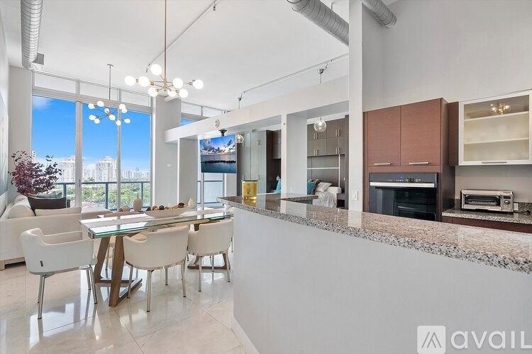 A modern kitchen with a dining table and chairs.
