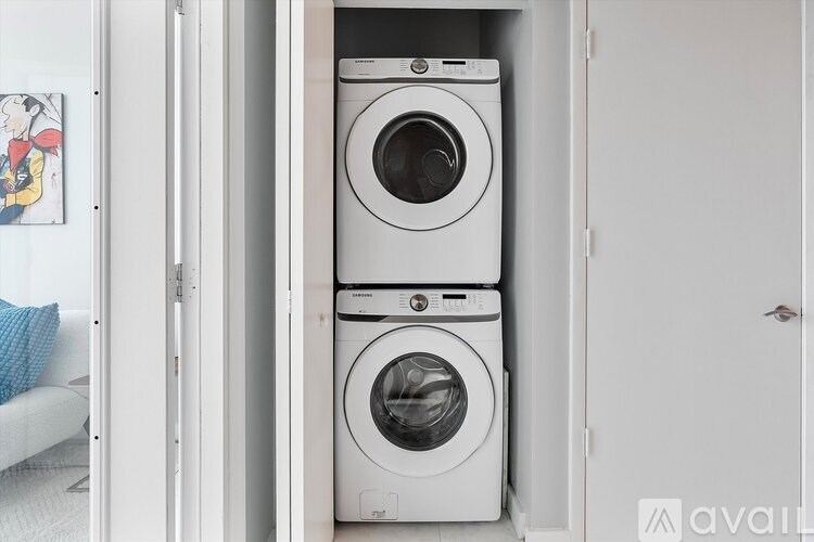 Two white front loading washing machines in a small laundry room.