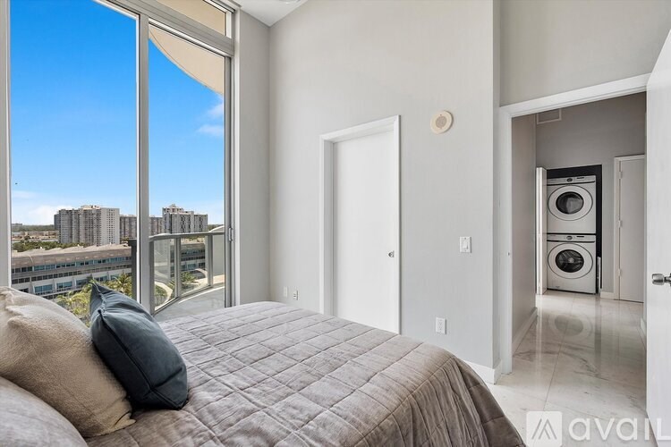 A bedroom with a large bed and a view of a city skyline.