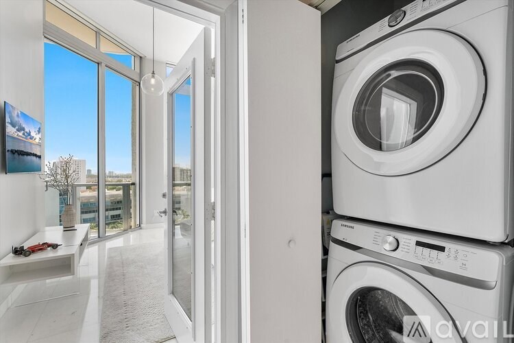 A stack of white front loading washing machines in a laundry room.