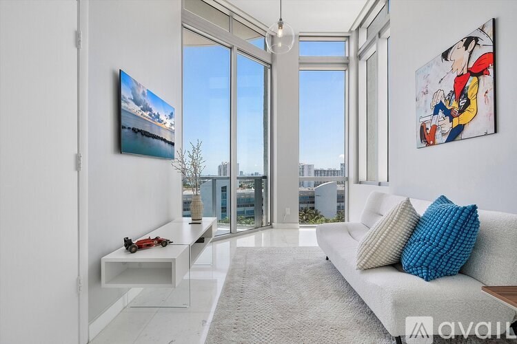 A living room with a white couch and a painting of a cartoon character on the wall.