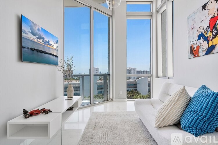 A modern living room with a view of the cityscape outside the large windows.