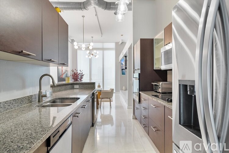 A modern kitchen with a sink, stove, and cabinets.