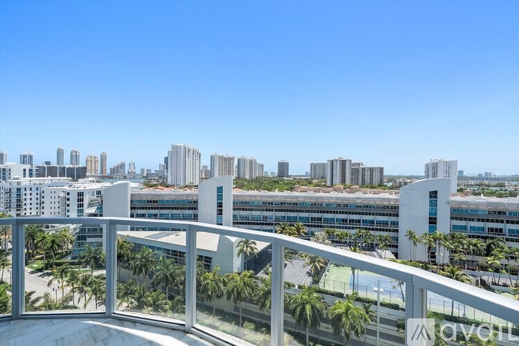 A balcony overlooks a cityscape with palm trees.