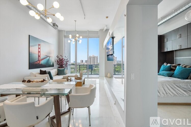 A modern dining room with a glass table and white chairs.