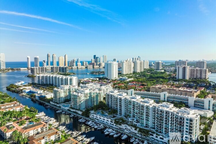 A cityscape with a mix of residential and commercial buildings, a marina, and a body of water.