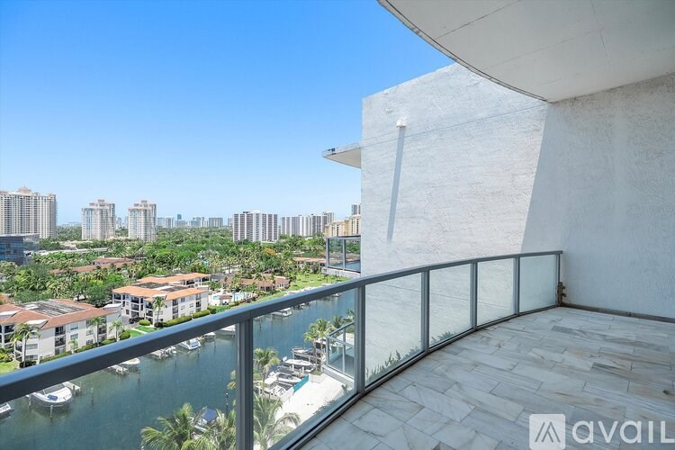 A balcony overlooks a waterfront with boats and buildings.