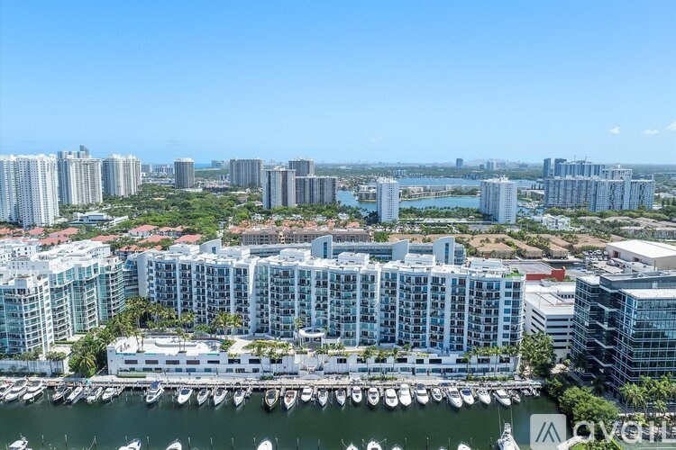 A cityscape with a marina in the foreground and a clear blue sky above.