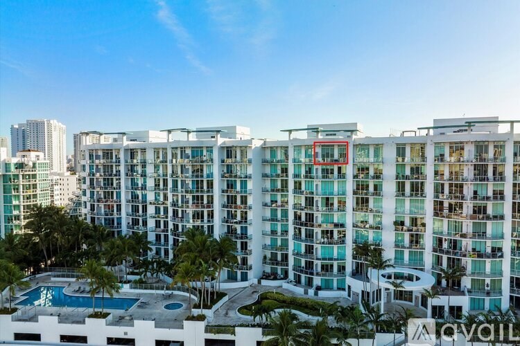 A large white building with a pool in front of it.