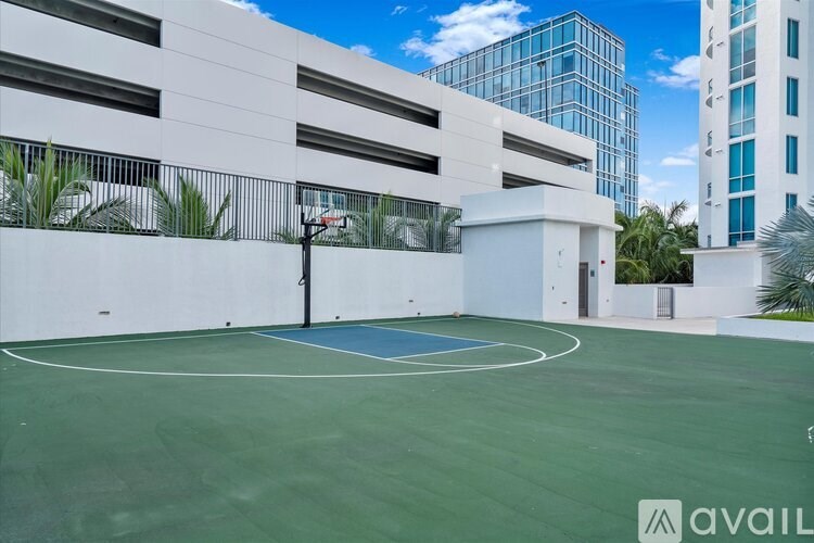 A basketball court is located in a courtyard surrounded by buildings.