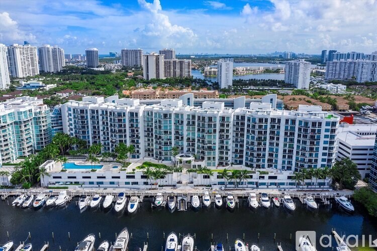 A marina with boats docked in front of a large white building.