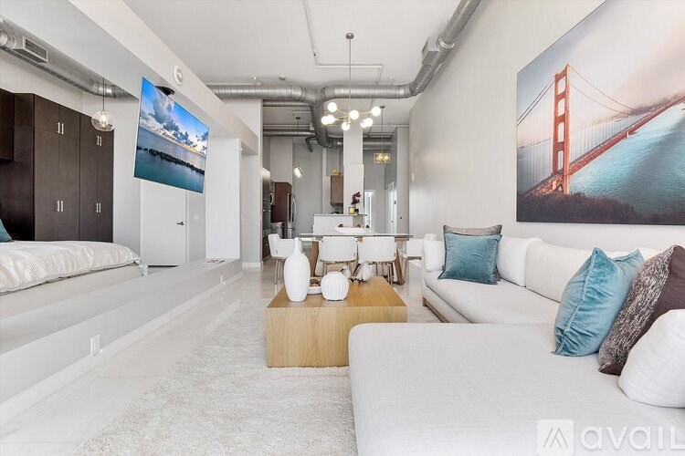 A living room with a white couch and a large poster of the Golden Gate Bridge on the wall.