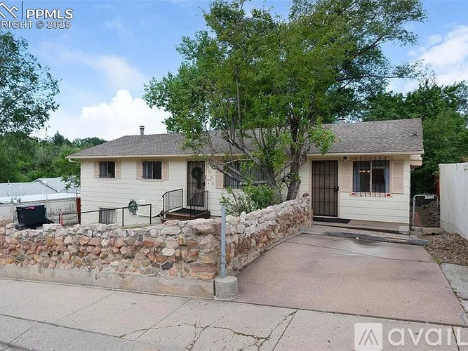 A house with a stone wall and a brown door is for sale.