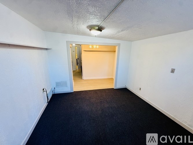 A room with a carpeted floor and a doorway leading to another room.