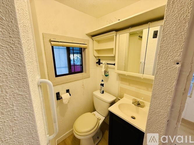 A small bathroom with a toilet, sink, and mirror.