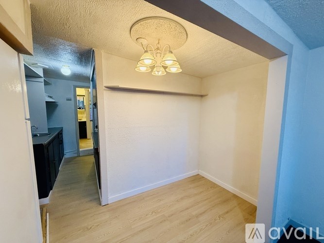 A room with a white wall and a light fixture on the ceiling.