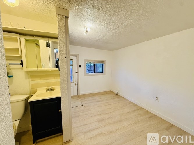 A bathroom with a toilet, sink, and a window.