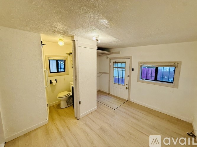 A room with a toilet and a window.