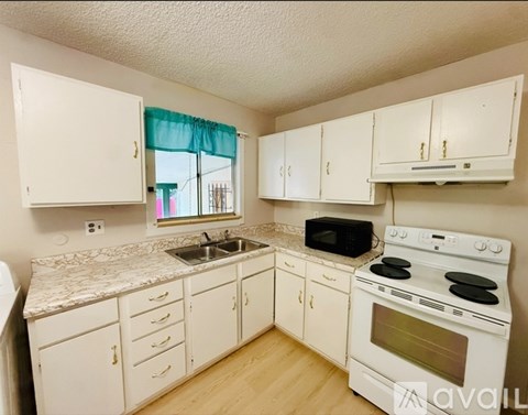 A kitchen with white cabinets and a granite countertop.