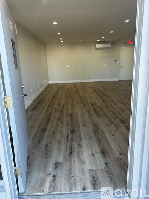 A room with wooden flooring and white walls.
