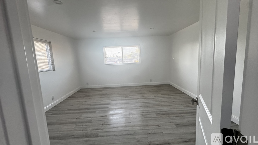 A room with wooden flooring and white walls.