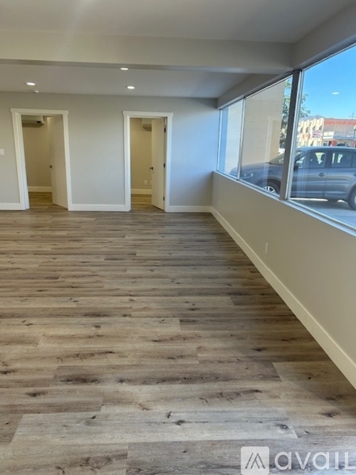 A room with wooden flooring and two doors.