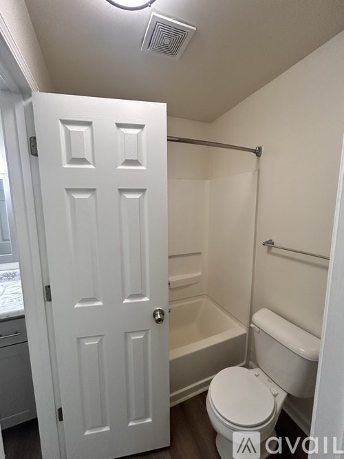 A white bathroom with a toilet, tub, and shower.