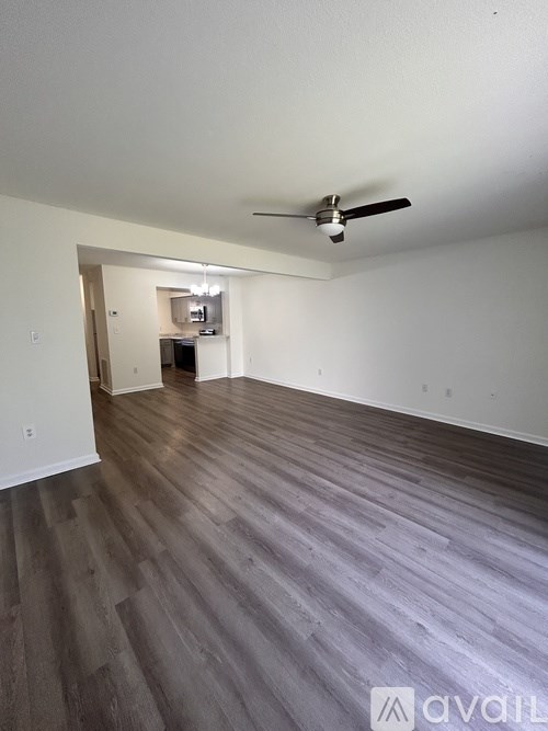 A room with a ceiling fan and wooden flooring.