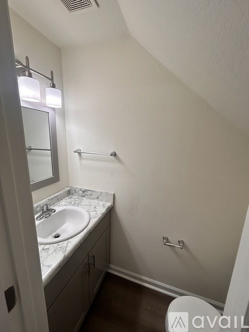 A bathroom with a marble counter top and a white sink.