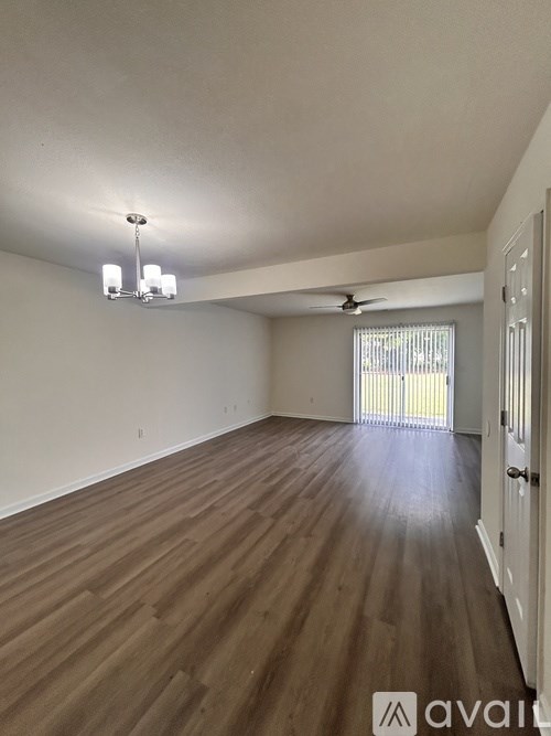 A room with wooden flooring and a ceiling fan.