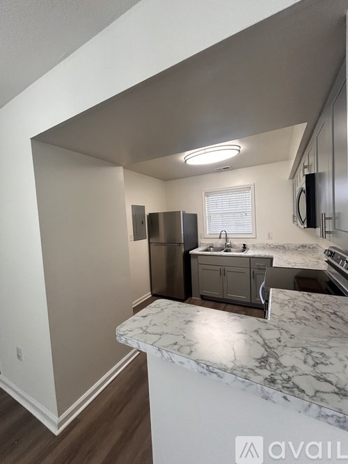 A kitchen with a marble countertop and stainless steel appliances.