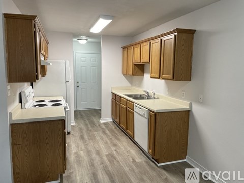 A kitchen with wooden cabinets and a white stove top oven.