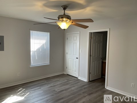 A room with a ceiling fan and a door.