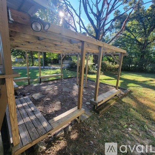 A wooden deck structure with a roof and a bench.