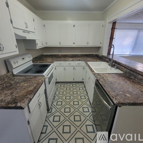 A kitchen with granite countertops and white cabinets.