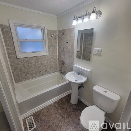 A bathroom with a toilet, sink, and bathtub.