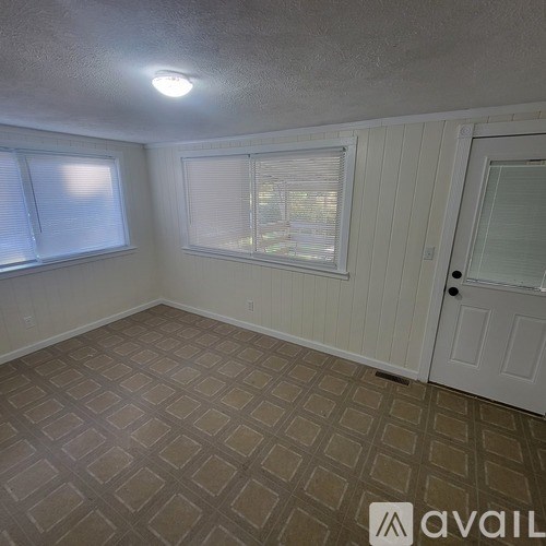 A room with a tiled floor and a white door.