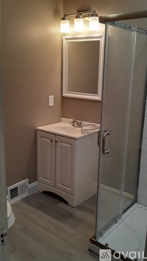 A bathroom with a white sink and a mirror above it.