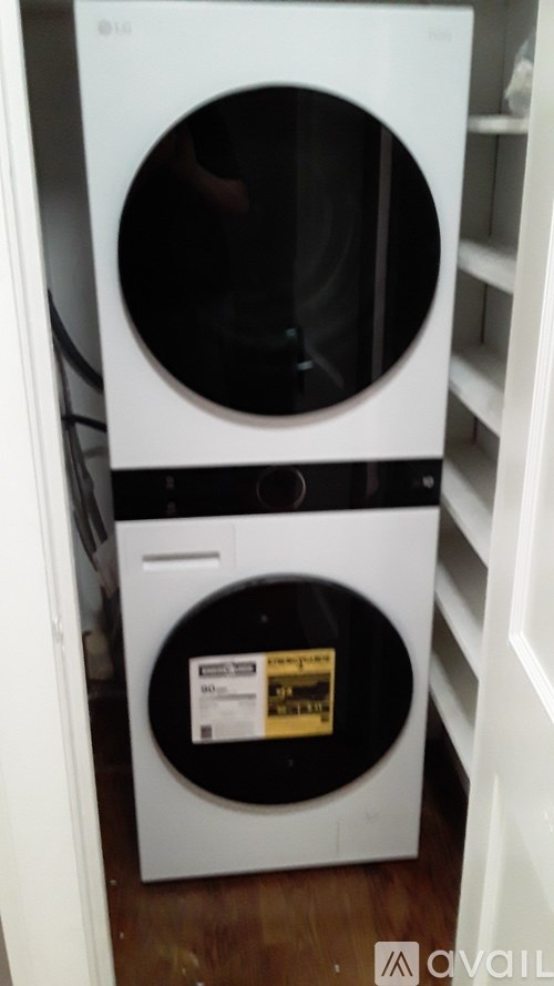A white front loading washing machine with a black door and a sticker on the door.