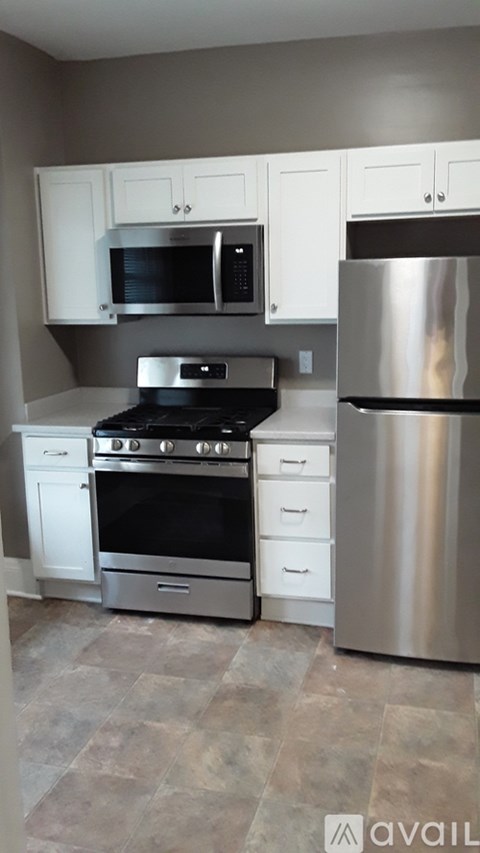 A kitchen with a stove, oven, microwave, and refrigerator.