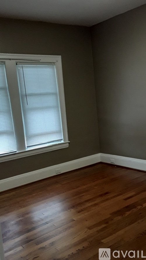 A room with a window and wooden floors.
