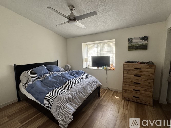 A bedroom with a bed, dresser, and window.