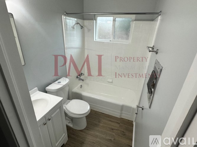 A white bathroom with a toilet, sink, and bathtub.