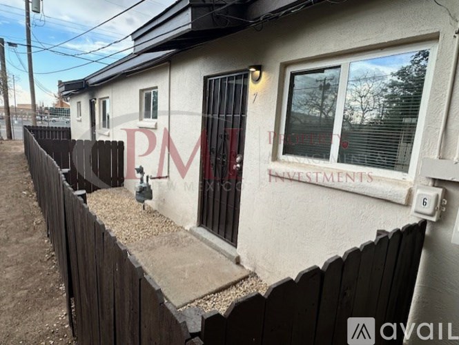 A house with a fence and a sign that says "PM" on it.