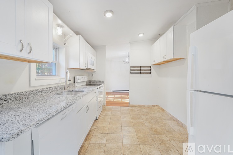 A kitchen with white cabinets and a granite countertop.
