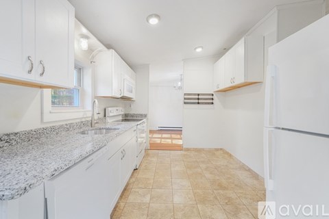 A kitchen with white cabinets and a granite countertop.