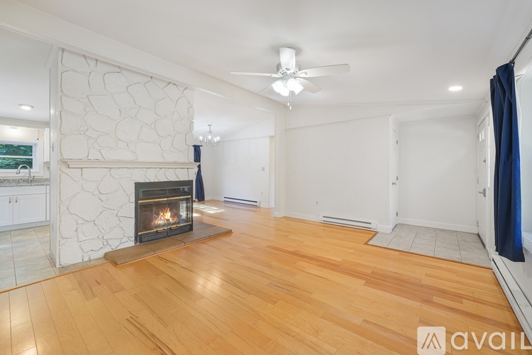 A living room with a fireplace and wooden floors.
