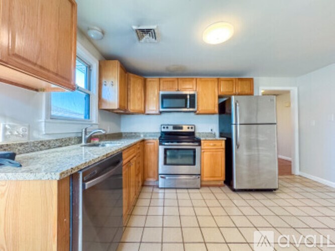 A kitchen with wooden cabinets and a tile floor.