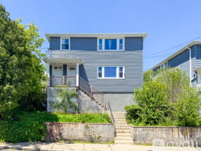 A two-story house with a grey exterior and white trim.