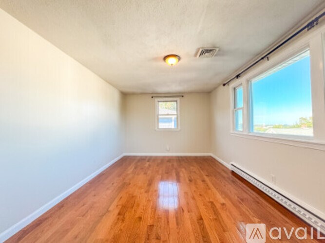 Empty room with wooden floor and white walls.
